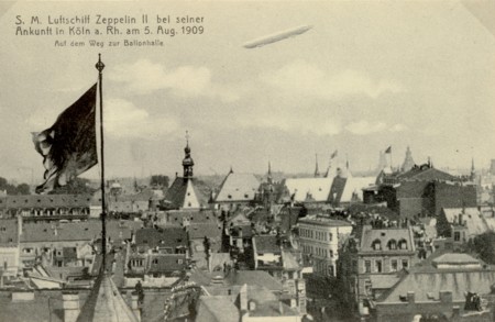 LZ II über Köln auf dem Weg zum Luftschiffhafen nach Köln-Bickendorf, Menschenmengen auf den Dächern