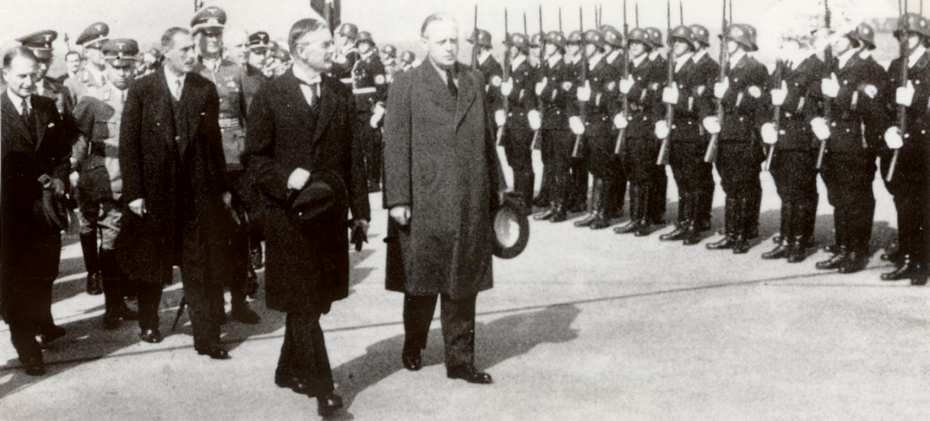 Premierminister Neville Chamberlaine schreitet mit Auenminister von Ribbentrop und Frhr. von Weizscker die Ehrenkompanie auf dem Flughafen Kln Butzweilerhof ab.