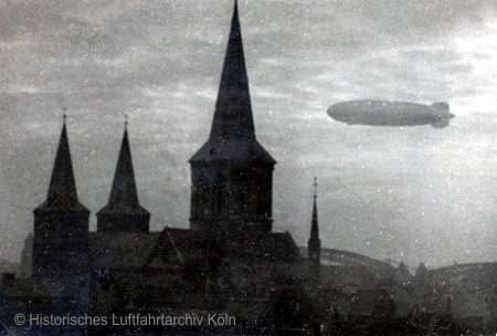 Die "Hindenburg" in Kln ber dem Deutzer Hafen auf Fahrt nach Norden. Im Vordergrund St. Kunibert